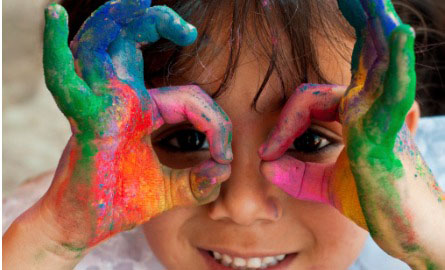 small girl playing with paint on her hands