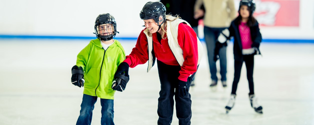 Boy learning to skate with an adult