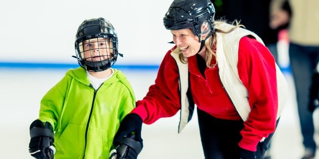 Boy learning to skate with an adult