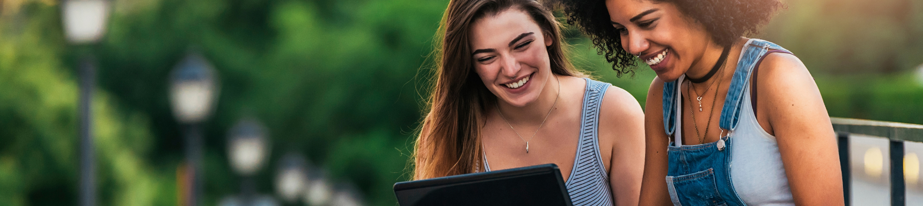 two young women looking at a laptop and smiling