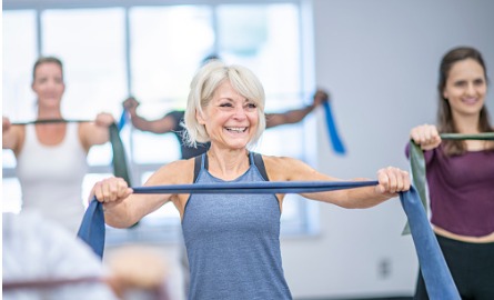 Older adult woman exercising on a stability ball.